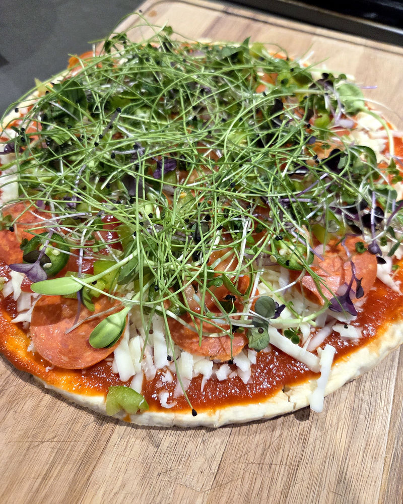 Homemade pepperoni pizza piled high with fresh microgreens
