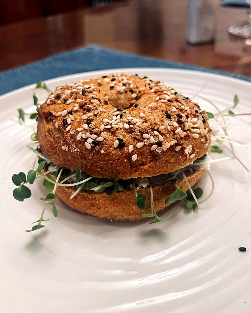 Everything bagel sandwich filled with cream cheese and fresh microgreens